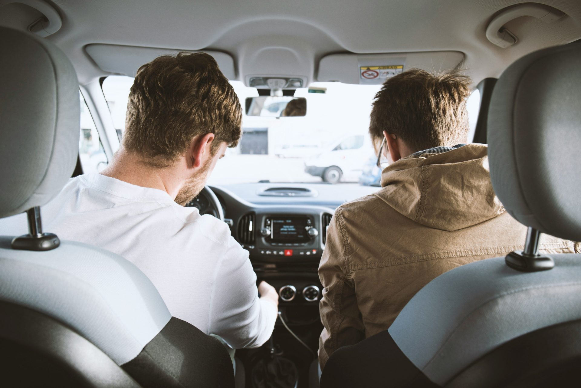 Zwei Männer sitzen in einem Fahrzeug.