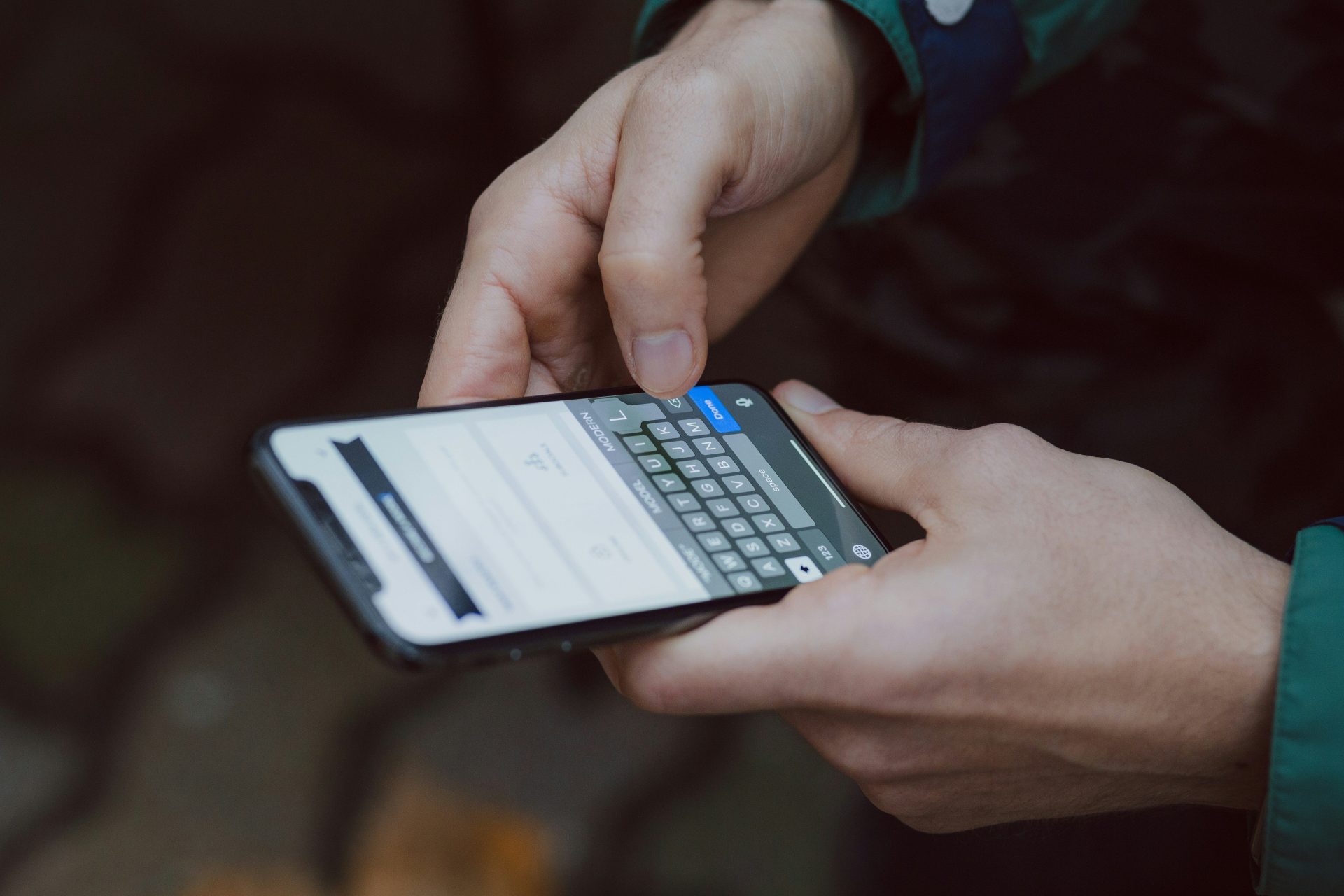 Fotografie mit selektiver Schärfe einer Person, die ein Smartphone benutzt